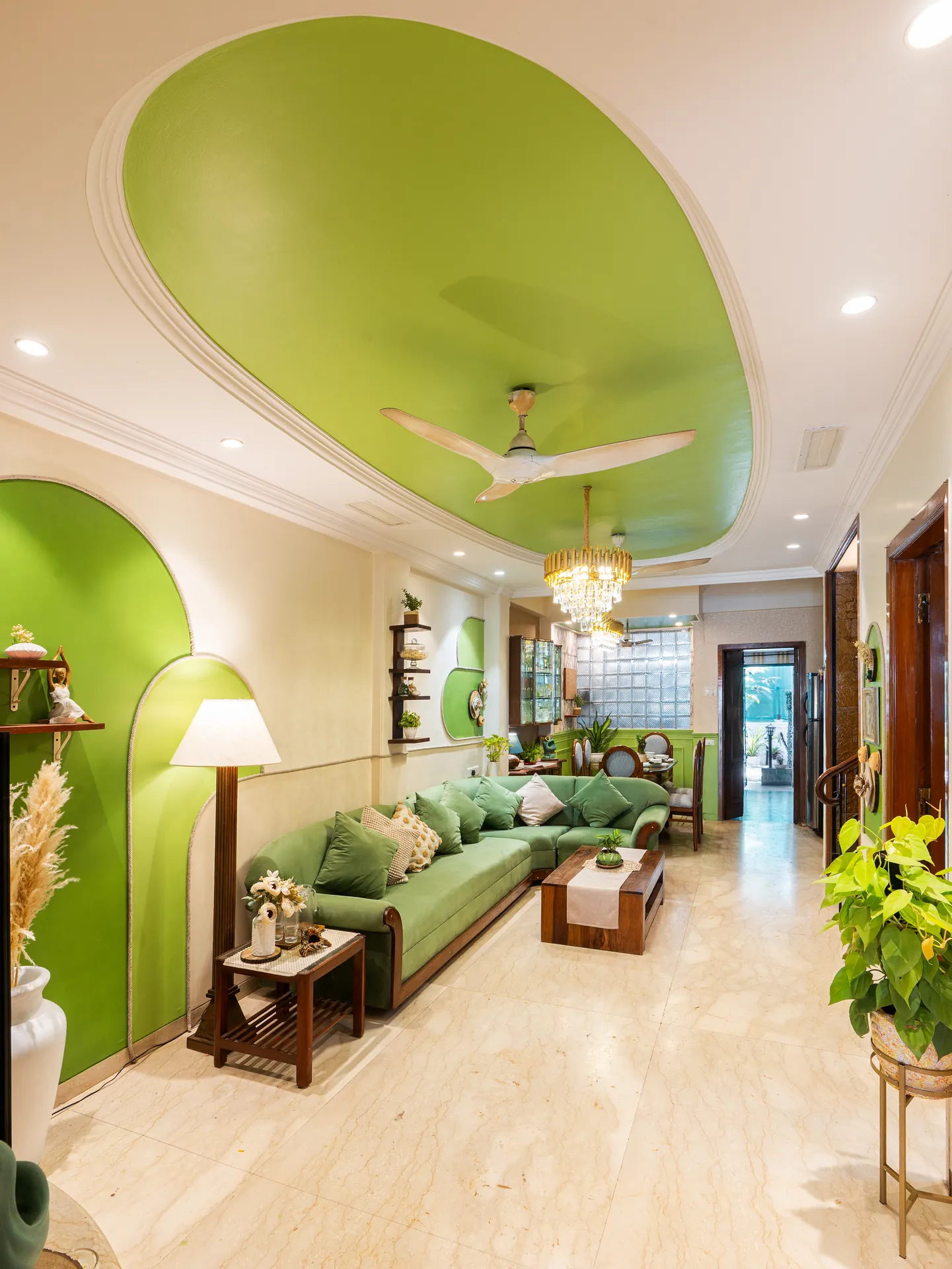 Living room with a green sofa, a green domed ceiling, a crystal chandelier and a view through to the dining area.