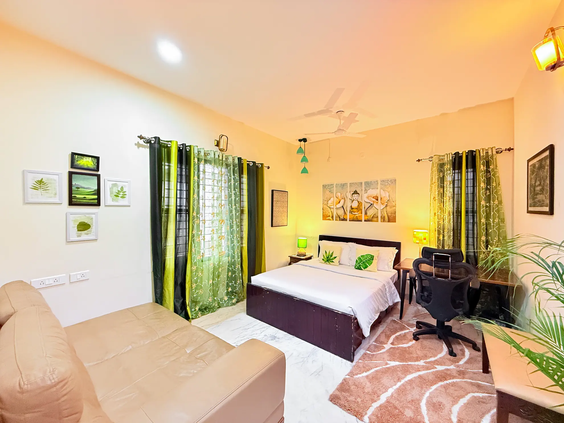 Bedroom with a double bed, green curtains, a leather sofa, and a desk with an office chair.